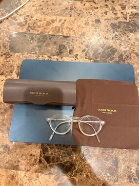Oliver Peoples brand women’s translucent glasses and brown case.